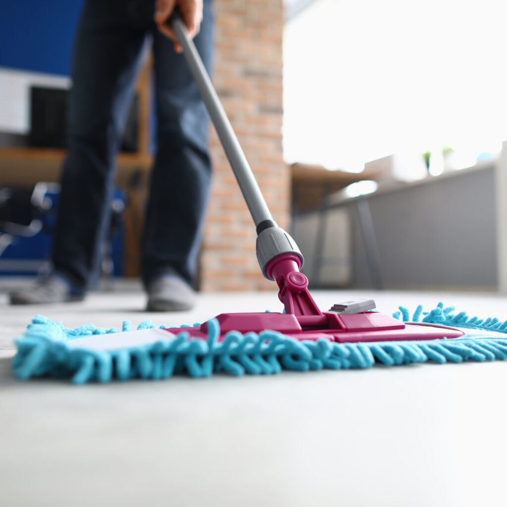 Man with Mop Washes Floor in Office Closeup